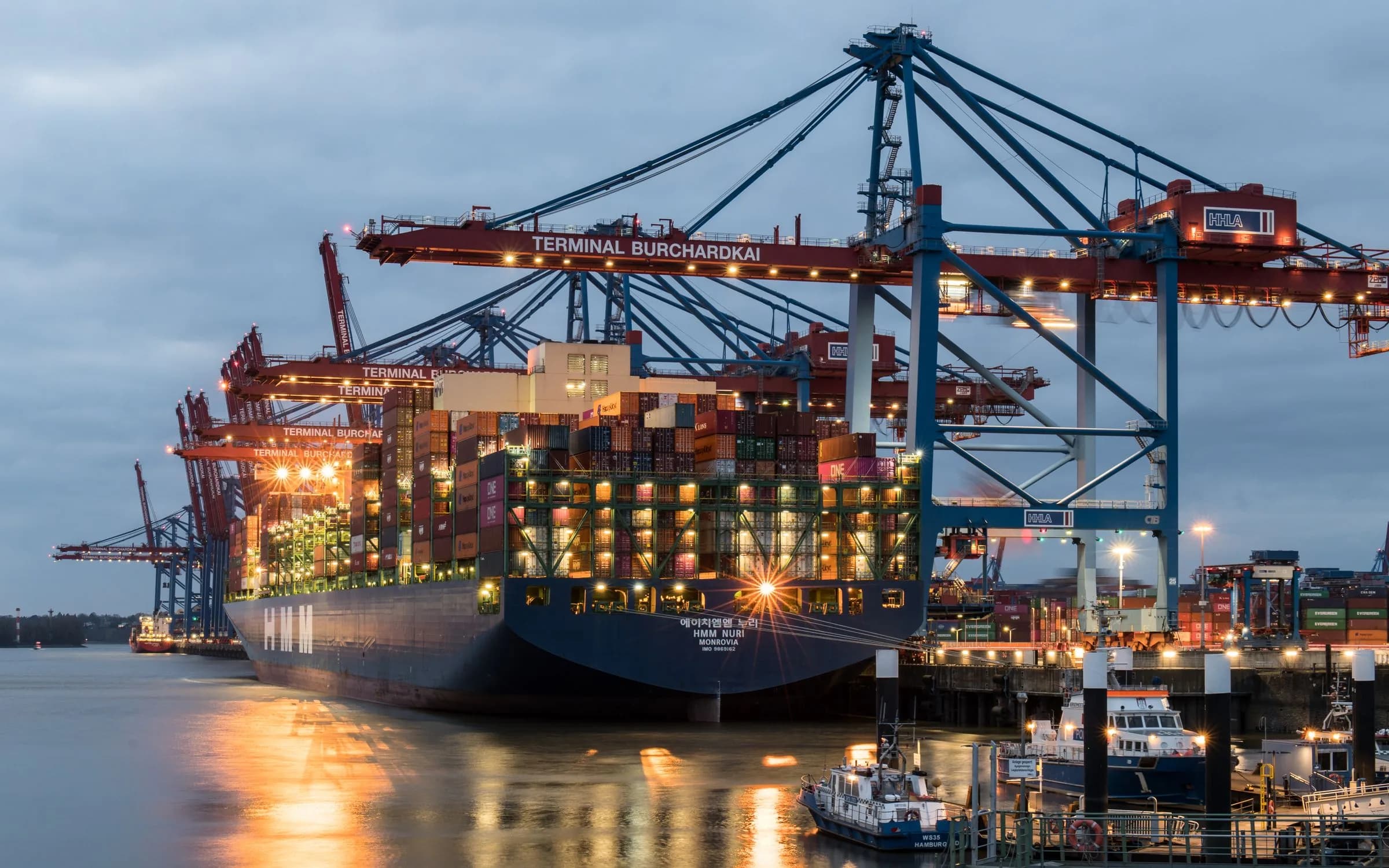 Port crane loading containers onto a vessel
